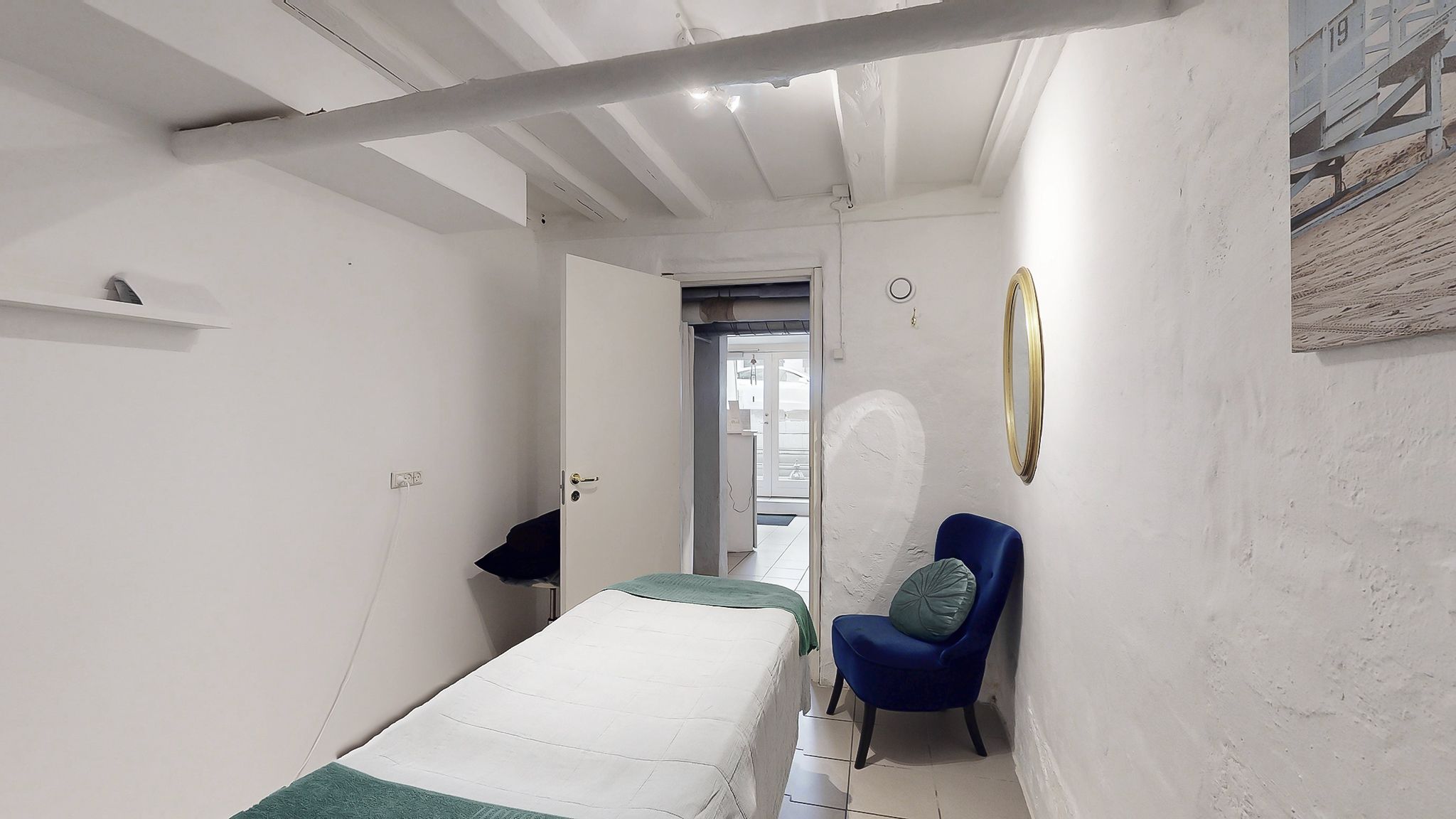 Køkken med lysegult lys, et bord og en lille sofa med pude og tæppe