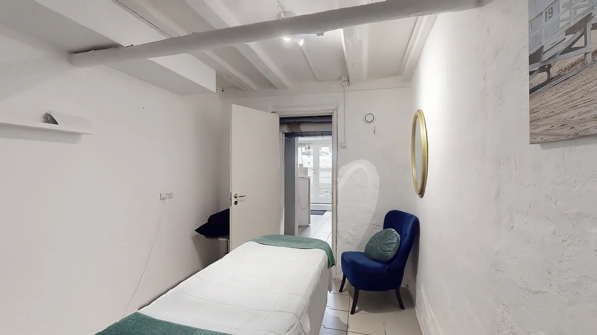 Køkken med lysegult lys, et bord og en lille sofa med pude og tæppe