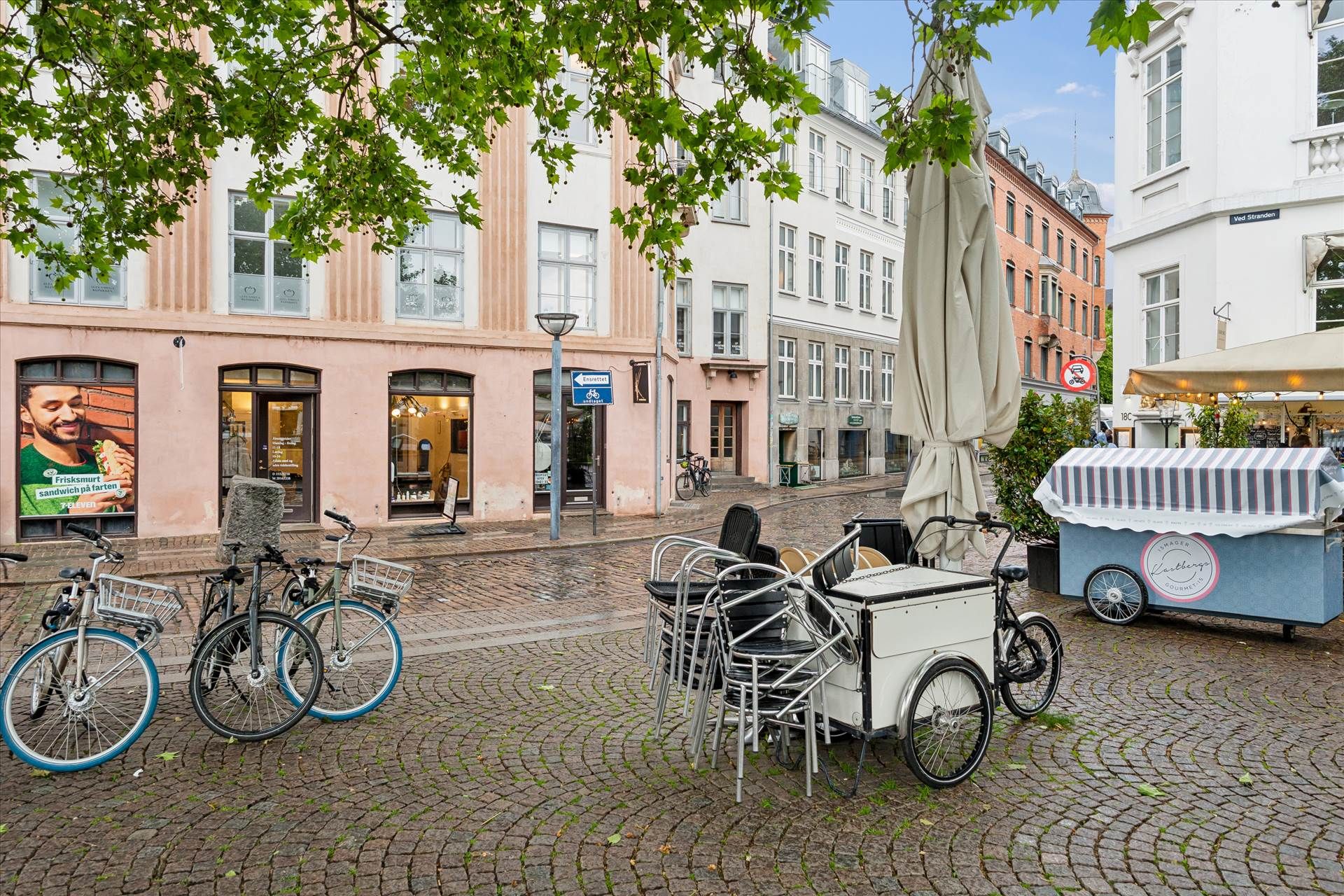 Flere cykler parkeret og en lukket bistrovogn i København og en lukket paraply