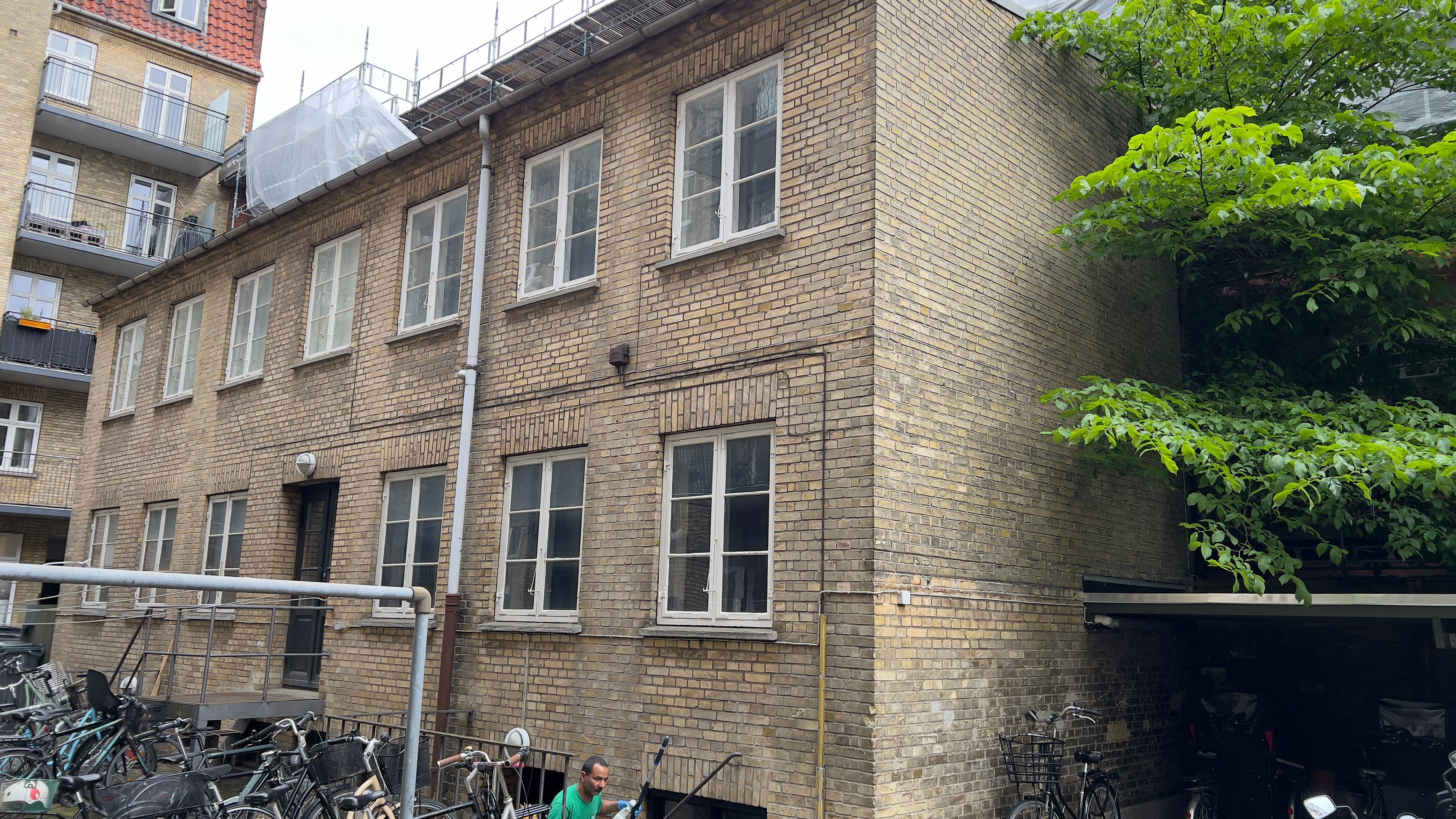 Lejemålet er en stor bygning med mange vinduer og flere cykler parkeret udenfor