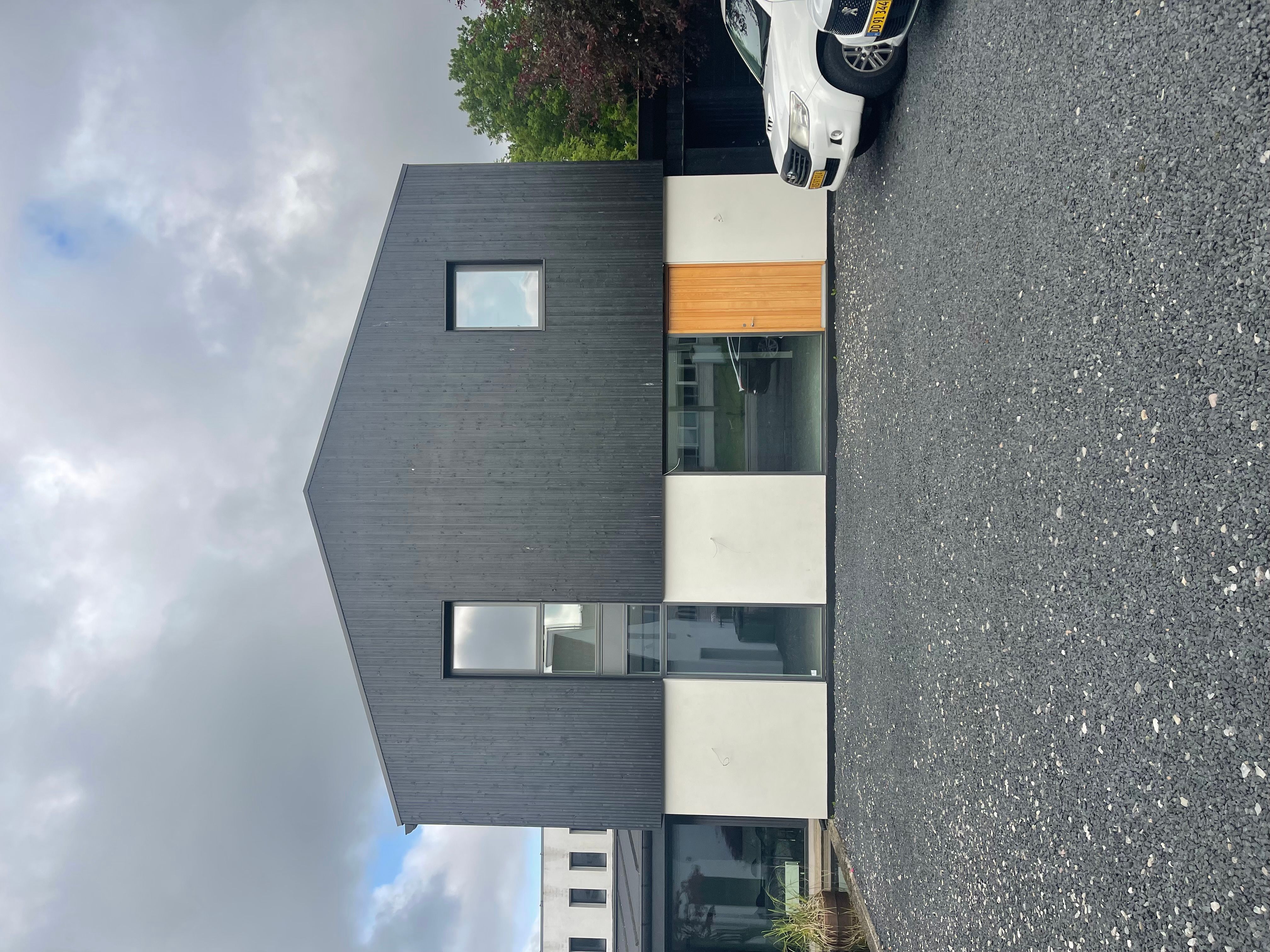 Moderne kontorbygning med glasvinduer og høj kvalitet. Bygningen er forsynet med et unikt vinkeldesign og en sort facade.