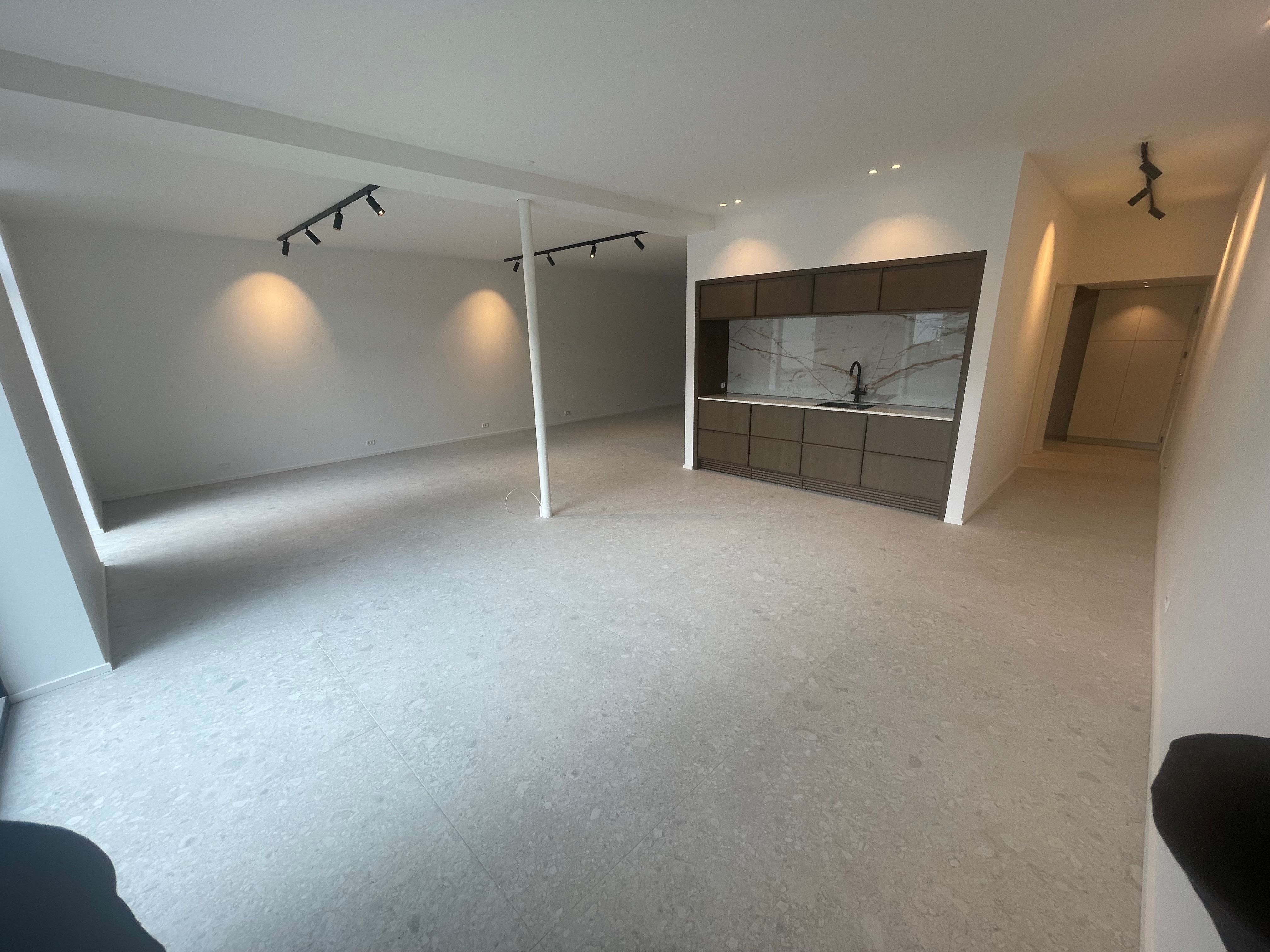 Nyistandsat kontor med marmorgulv, hvide vægge, lysekroner og moderne køkken med granitbordplade og rustfrit stålhåndvask