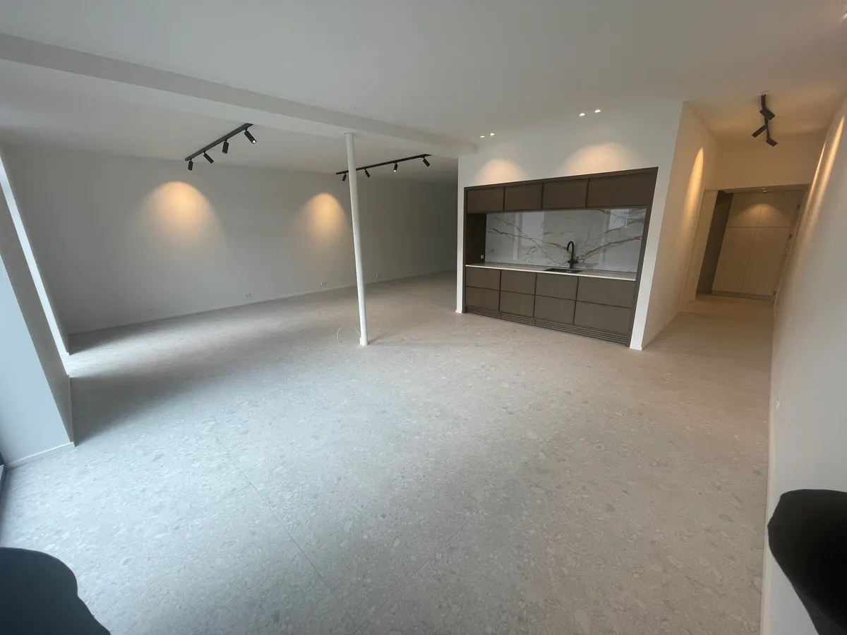 Nyistandsat kontor med marmorgulv, hvide vægge, lysekroner og moderne køkken med granitbordplade og rustfrit stålhåndvask