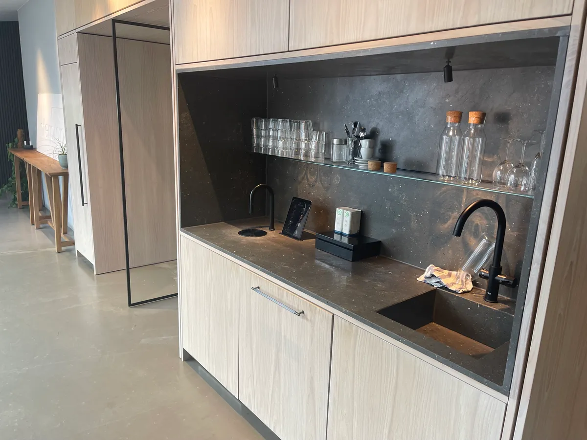 Moderne køkken med granit udvendig, lyse eg-skabe, smukke sort-grå fronter, samme farve på underskabet og lysegreb, lyse