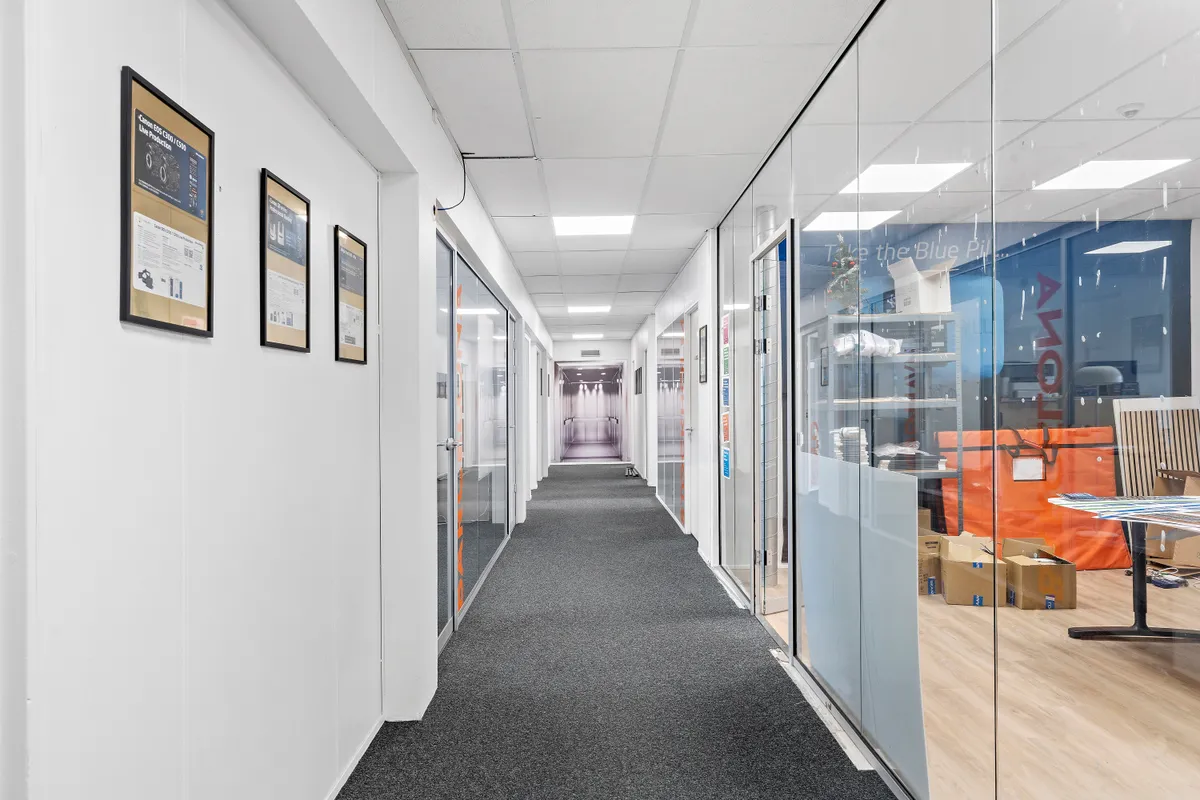 Lejlighed med 311 kvm til leje og indrettet med moderne kontorrum, hvor væggene er hvide og gulve er mørkegrå, og der er