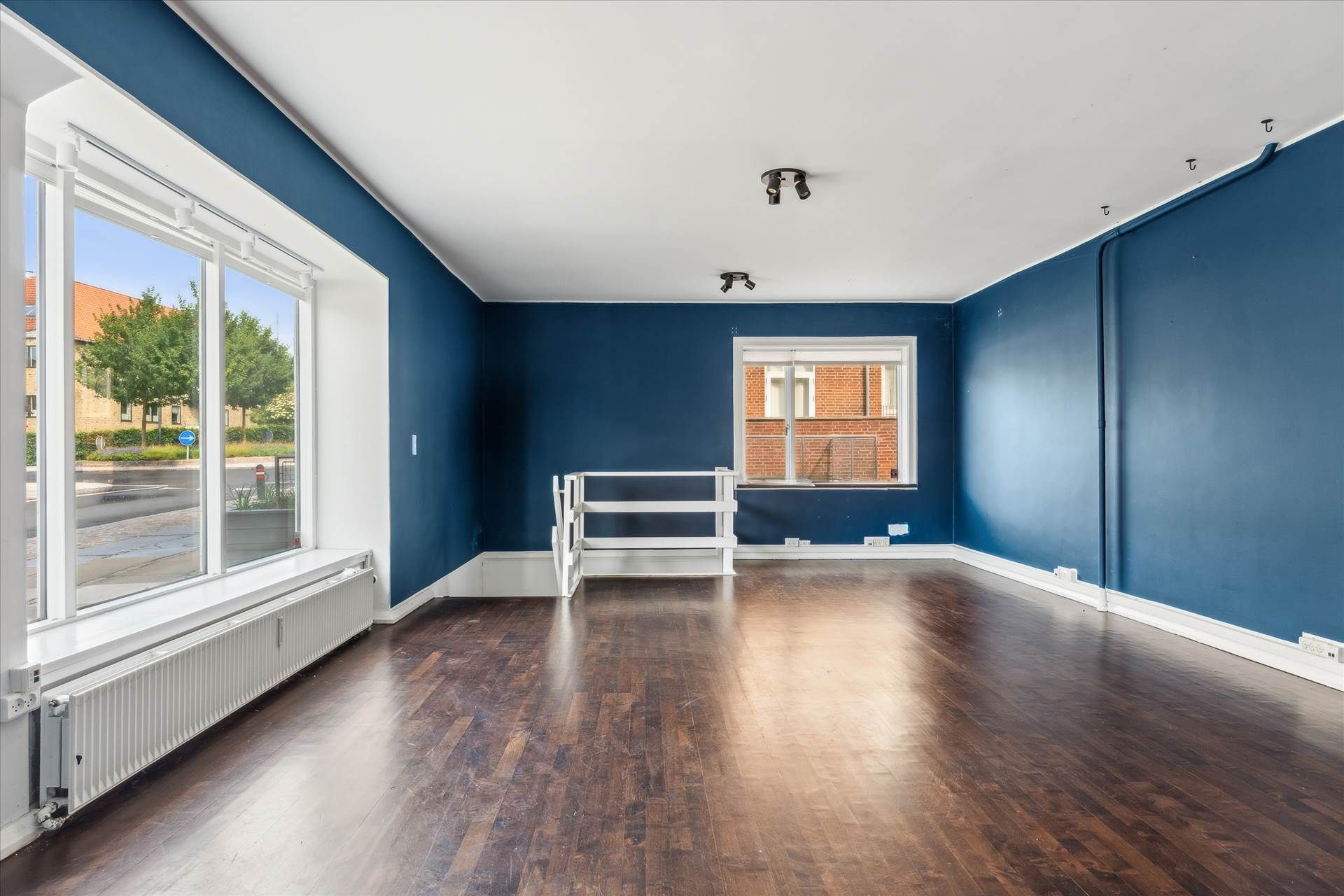 Lejlighed med højloftede værelser og gulvbelægning af træ og udvendige vinduer med dobbeltglas. Loftet er hvidt og væggene