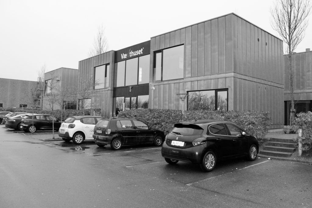 Kontorhotellet har facade mod E45 og er opbygget som en unik kontorpark. Parkerede biler står foran bygningen.