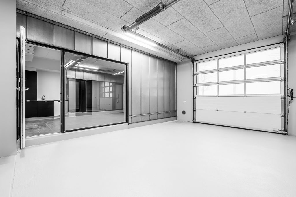 Store glasruder og åbne døre tilbyder et flot udsigtsvindue til en møbelskåret indretning med skarpe linjer og store vinduer