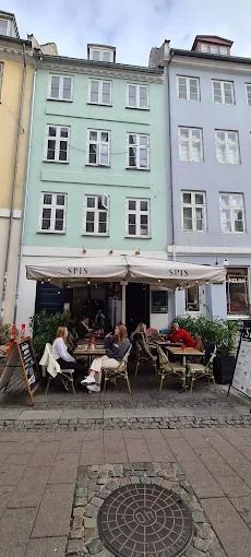 Folk sidder på terrassen udenfor spisested Spis i København med udsigter over gårde og grønne planter