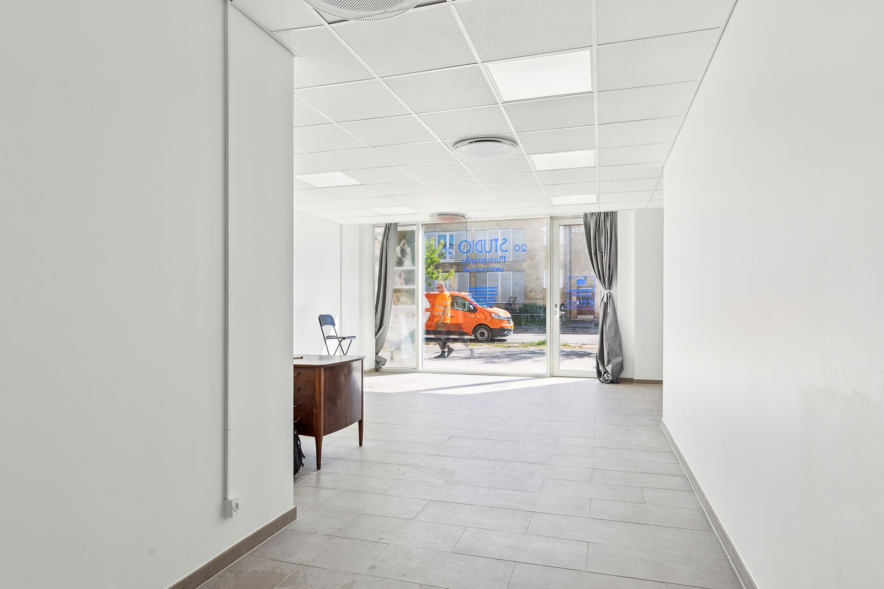 Store butikslokaler med højt loft og store vinduer mod gaden og en indgangsdør i glas