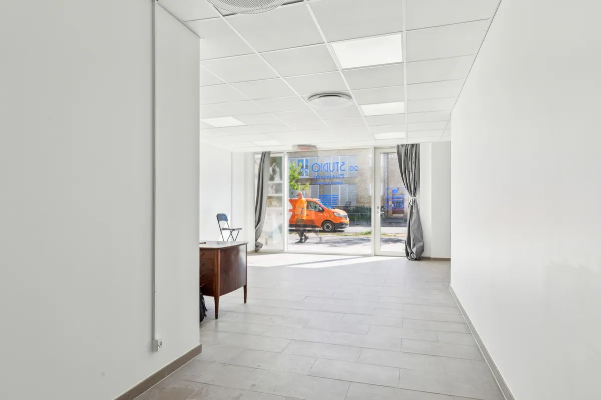 Store butikslokaler med højt loft og store vinduer mod gaden og en indgangsdør i glas