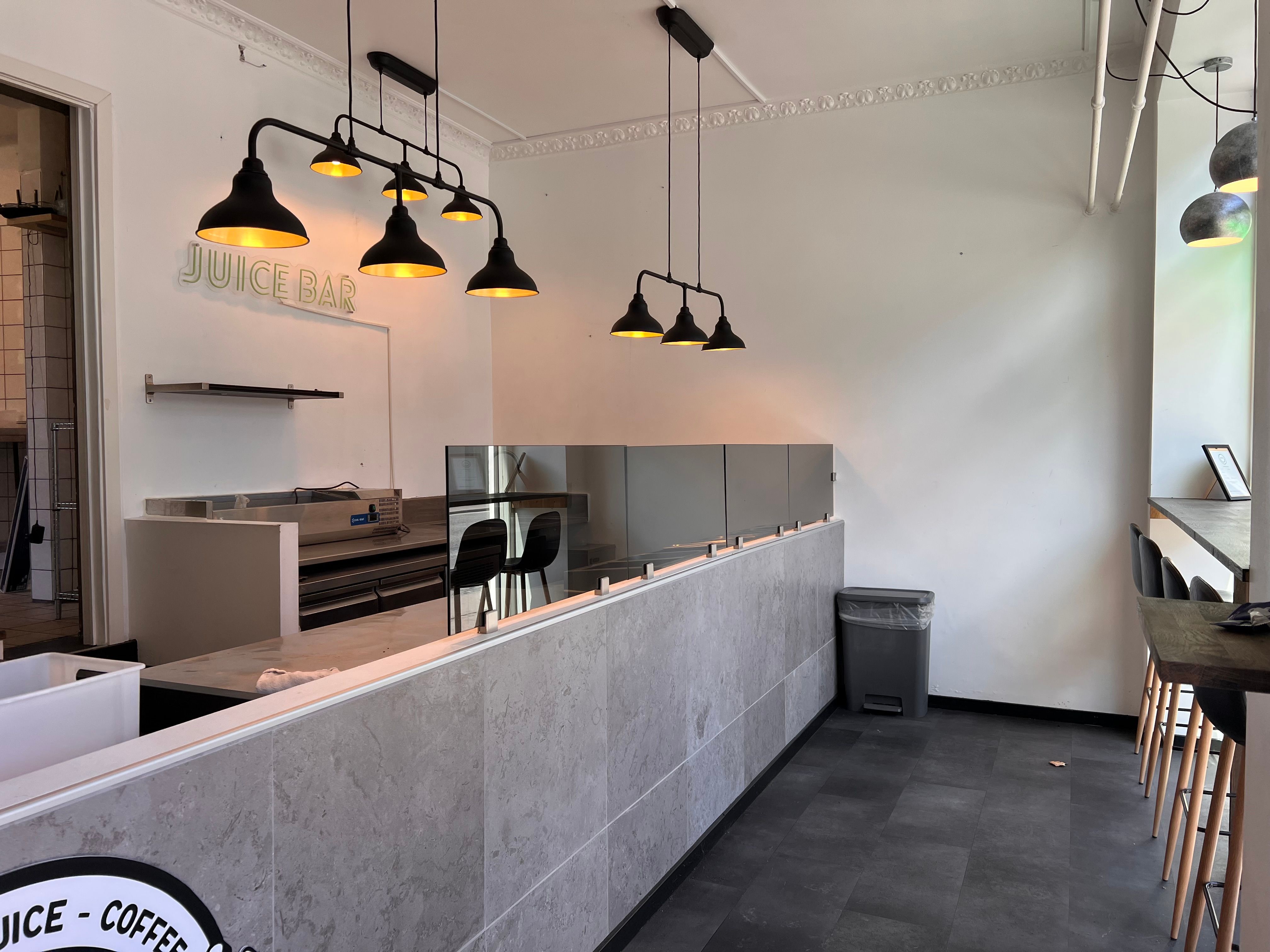 Foto af en Juice Bar med udstyr og møbler samt en stol og et bord i baggrunden