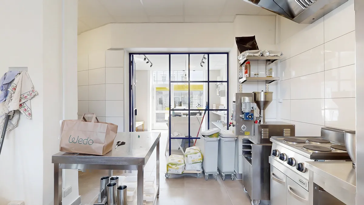 Lejemål med køkken med metalbord, rullekurve, komfur, ovn og loftslampe på Jernbane Allé i Vanløse