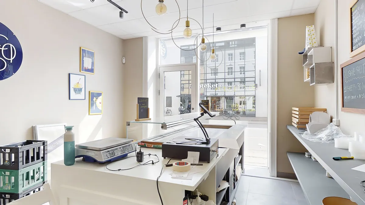 Køkken med vægte, skrivebord, lamper, lysekroner og udsigt til gaden i Vanløse