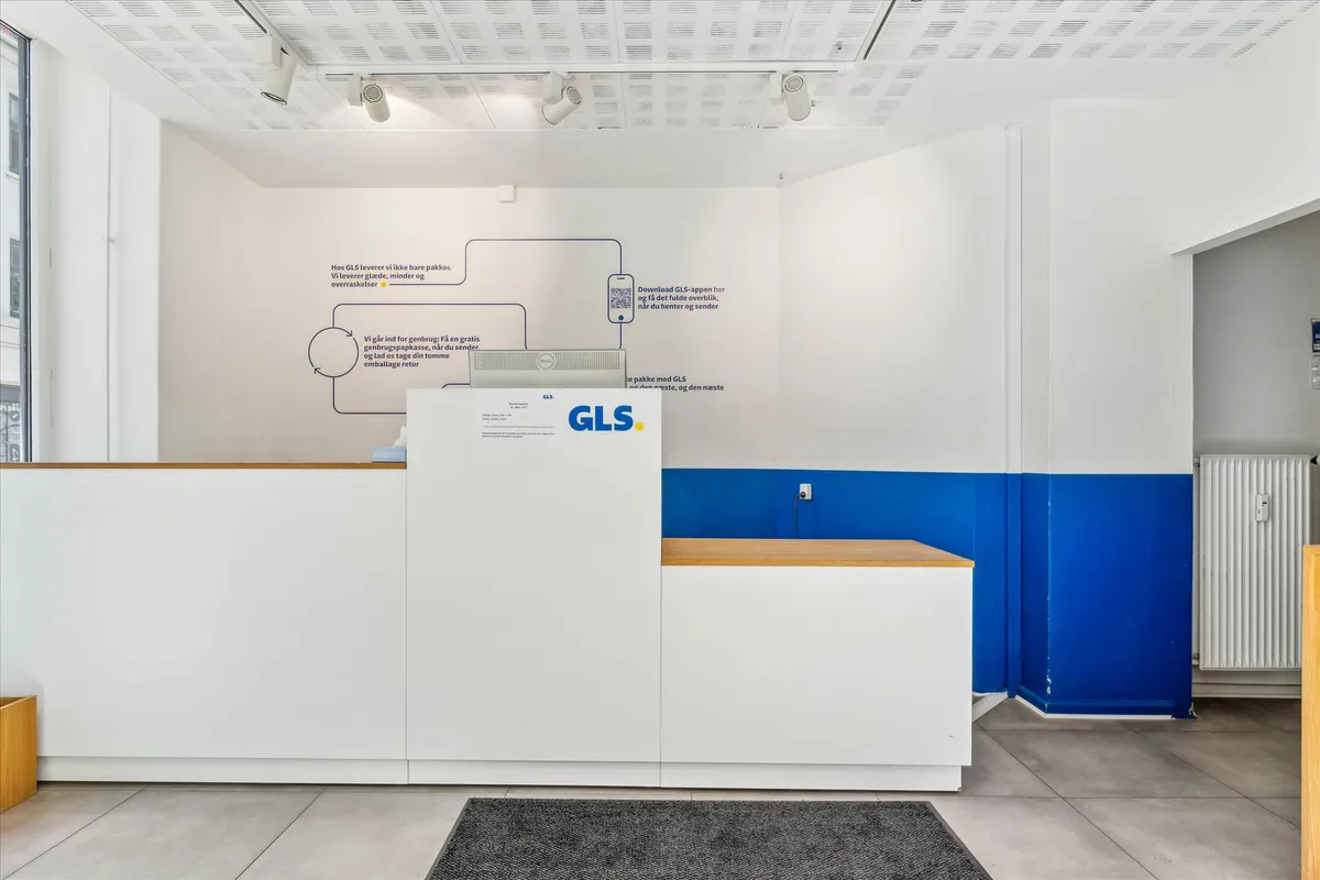 Minimalistisk kontorudsmykning med hvid og blå væg, gulv og møbler, med en brynstensgrå gulvtæppe og en hvid skranke med en