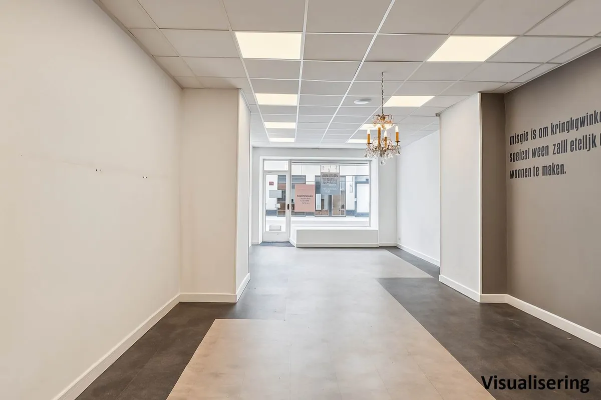 Lejlighed til butiksforretning i Værnedamsvej, uden møbler, men med tekst på væggen og lysekroner.