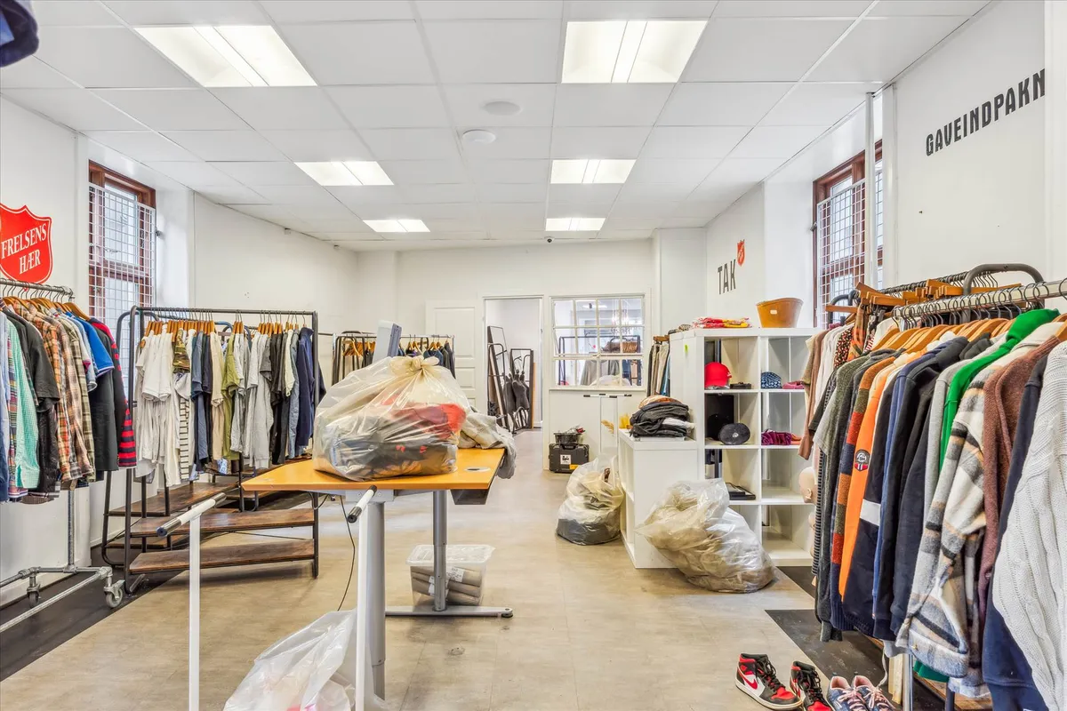 En butik med klæder og sko og indretning med højloftede lofter og mange lysekroner