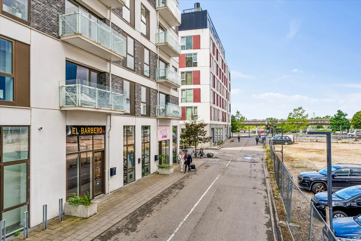 Et moderne kontorbyggeri med store glasvinduer og en stor parkeringsplads. Butikker og kontorer med store vinduer og