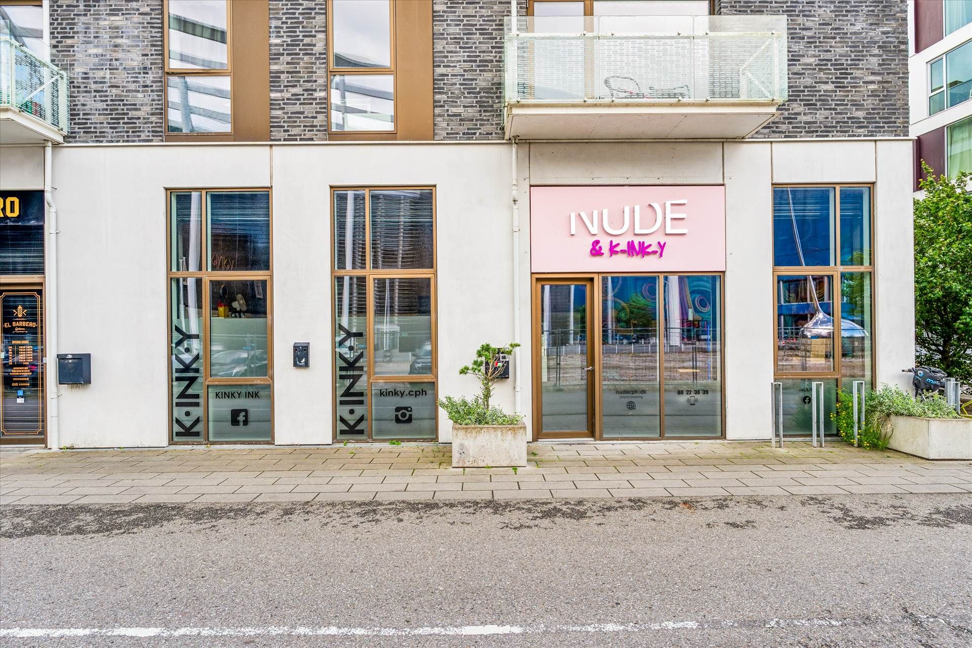 Butikslokaler med udsmykning i pink og skrifttypen Kinky Ink. Lokaler med store ruder og terrasse med udsigt over gaden.