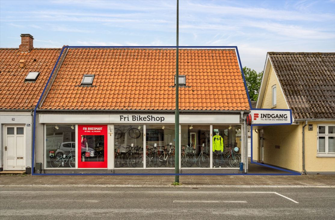 Fri BikeShop i Middelfart med en række cykler udstillet i vinduet og et stående skilt med texten "Fri BikeSmart"
