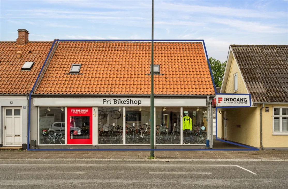 Fri BikeShop i Middelfart med en række cykler udstillet i vinduet og et stående skilt med texten "Fri BikeSmart"