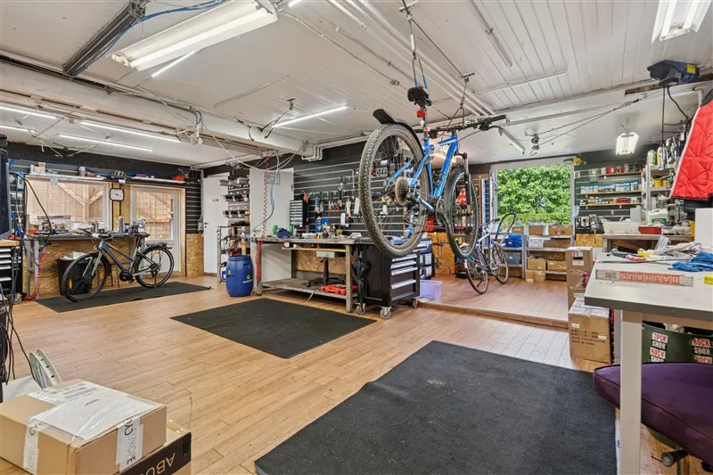 I et værksted hænger en cykel i loftet og der er flere værktøj og møbler