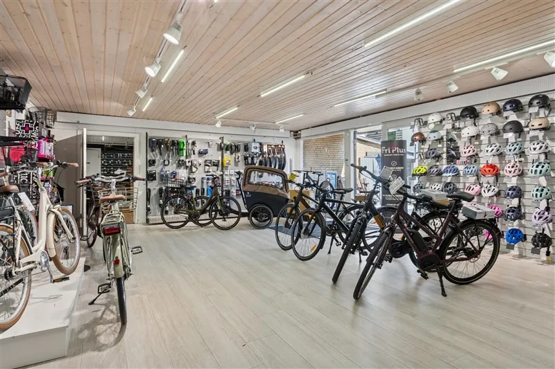 Cykelforretning med udstilling af forskellige cykler og hjelm samt lysekroner og vinduer i loftet