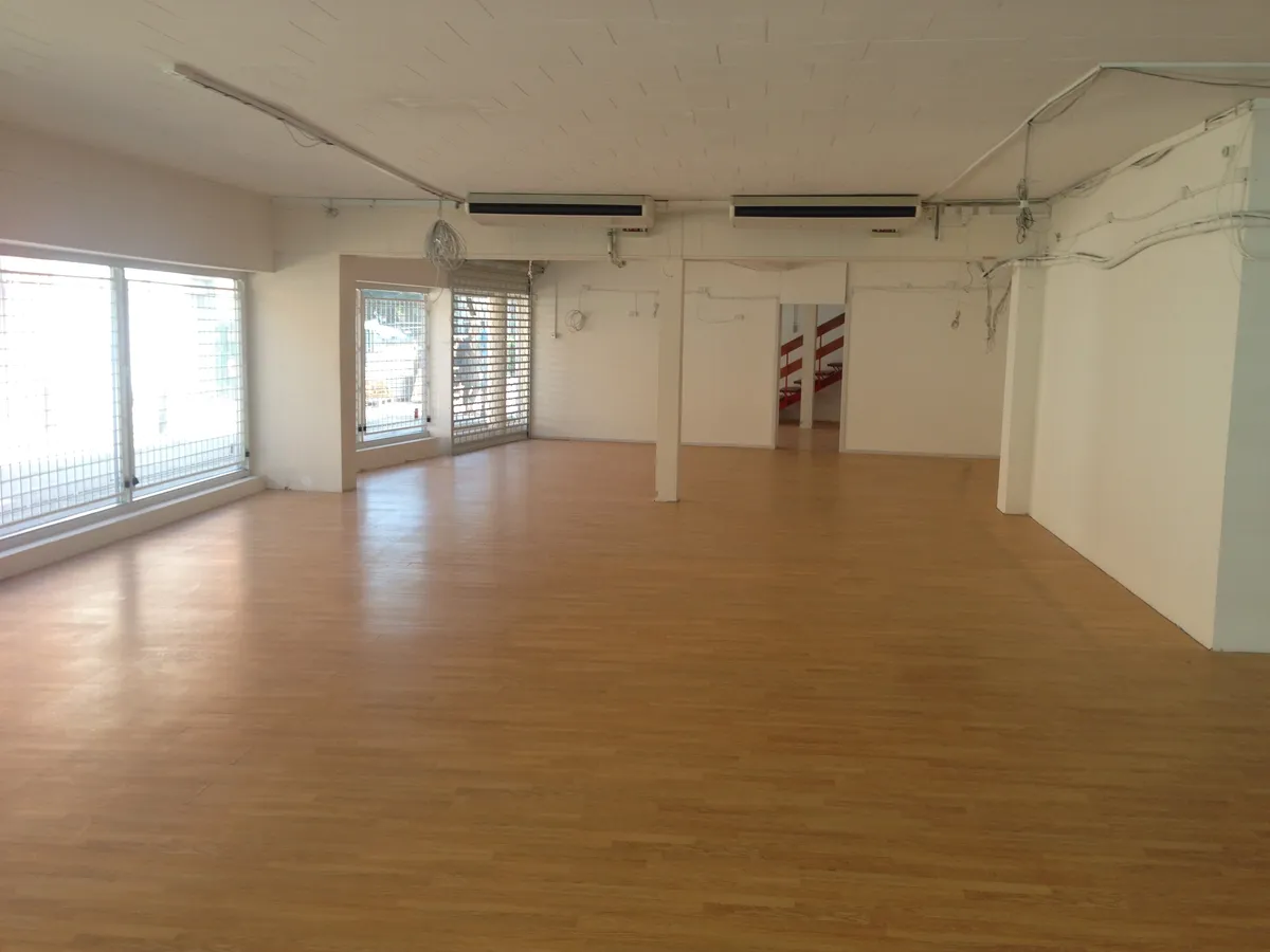 En tom lejlighed med hårdt trægulv, glasruder og to luftkøler på loftet