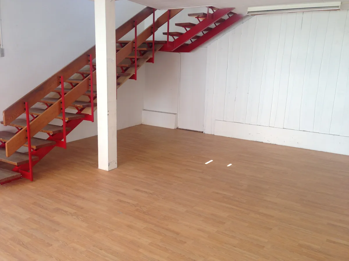 Store lejlighed med loft og højloft, to forskelige typer gulvbelægning og røde trapper.