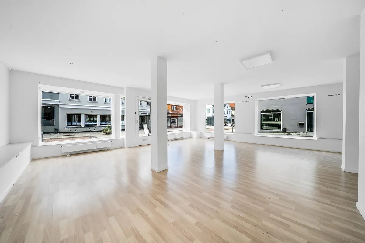 Butikslokaler med lyse lofter og gulv samt store vinduer mod gaden