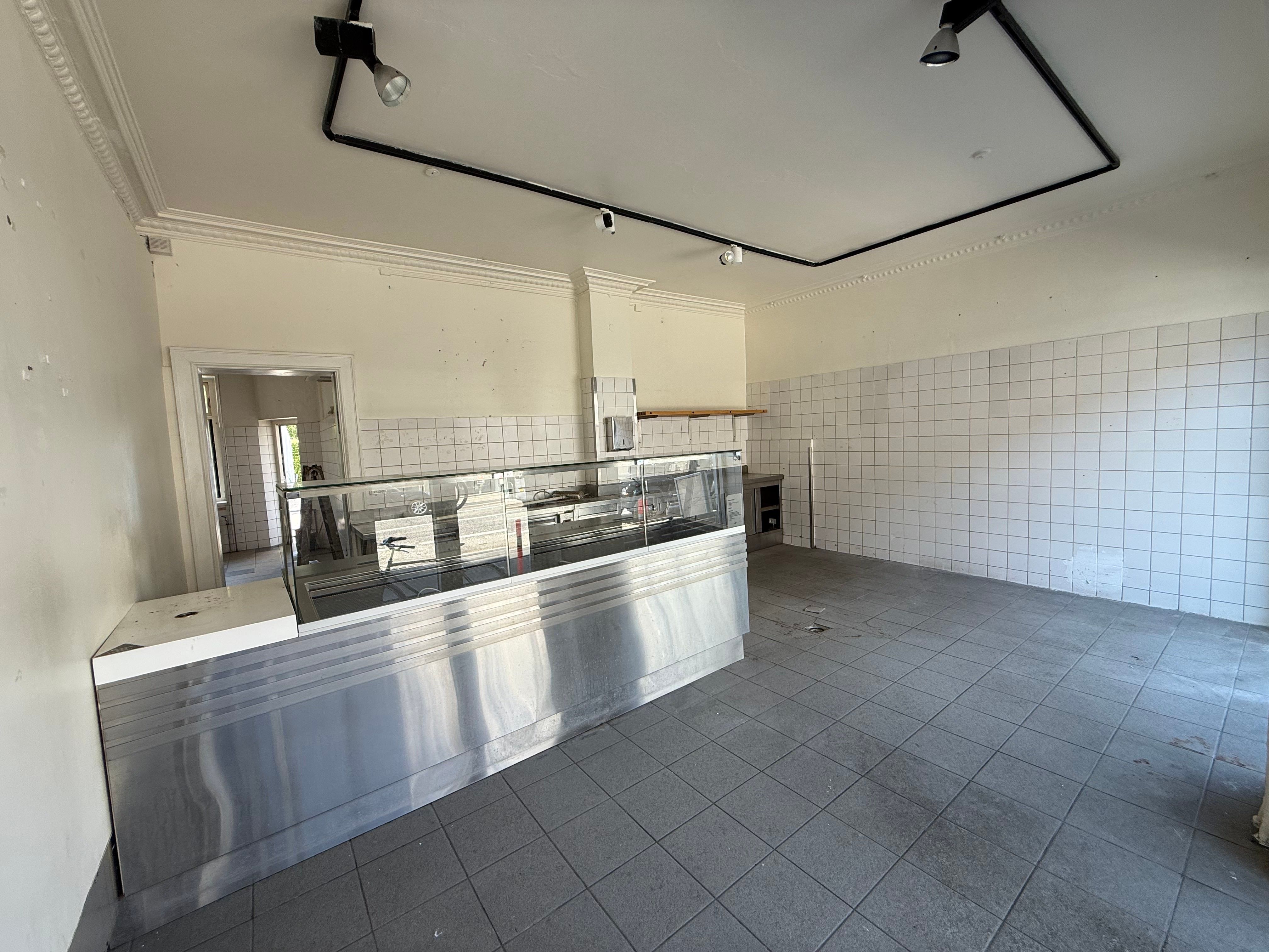 Et køkken med en stor rustfri stål forsalgsdisk og en lagerskab med en glasdør