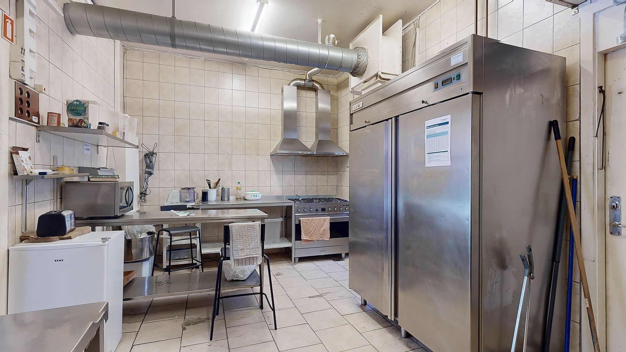 Erhvervslokaler med moderne køkkenindretning, hvor der er flere køleskabe, ovn, gaskomfur og apparater som mikroovn,