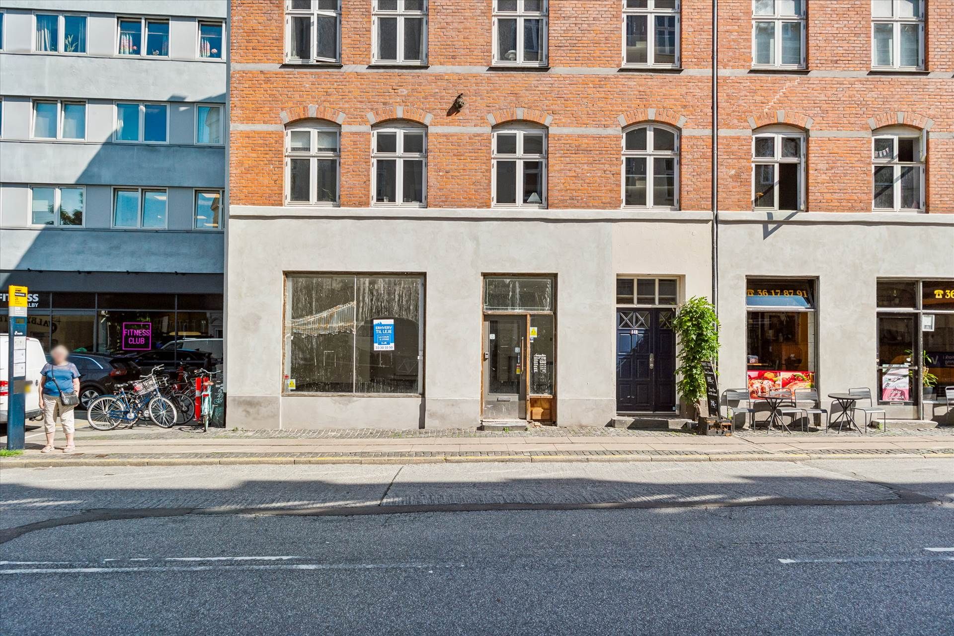 Erhvervslejemål med indgang og vinduer i centrum af København, tæt på adgangsveje og parkeringsmuligheder.
