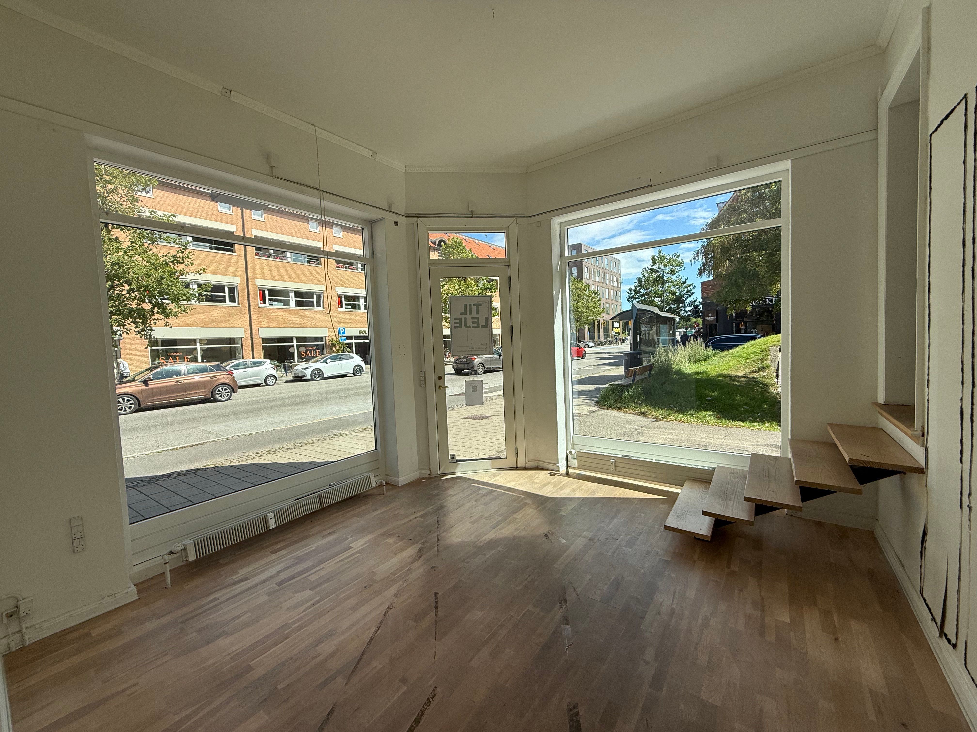 Tomt lokale med åbne ruder og smukke trægulve med adgang til gaden og stigning til øverste etage