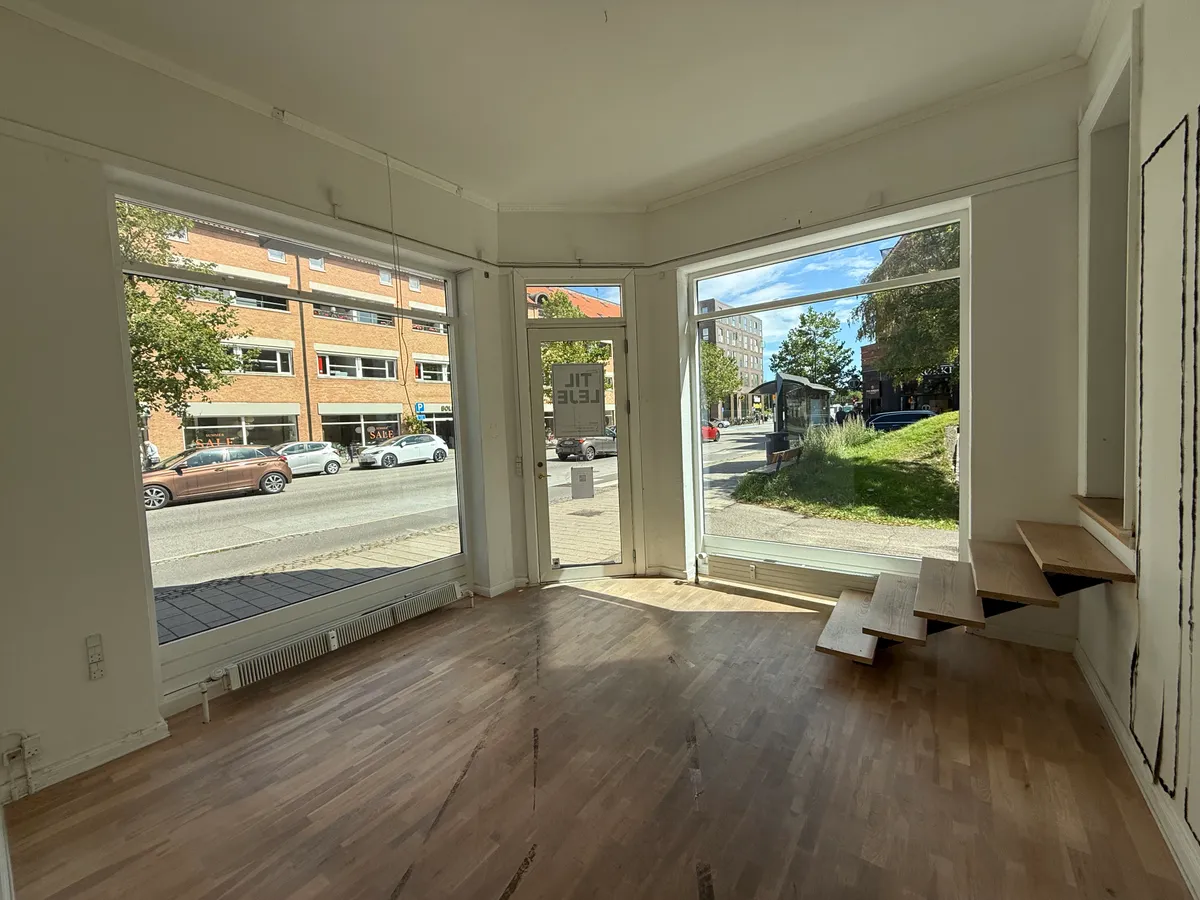 Tomt lokale med åbne ruder og smukke trægulve med adgang til gaden og stigning til øverste etage