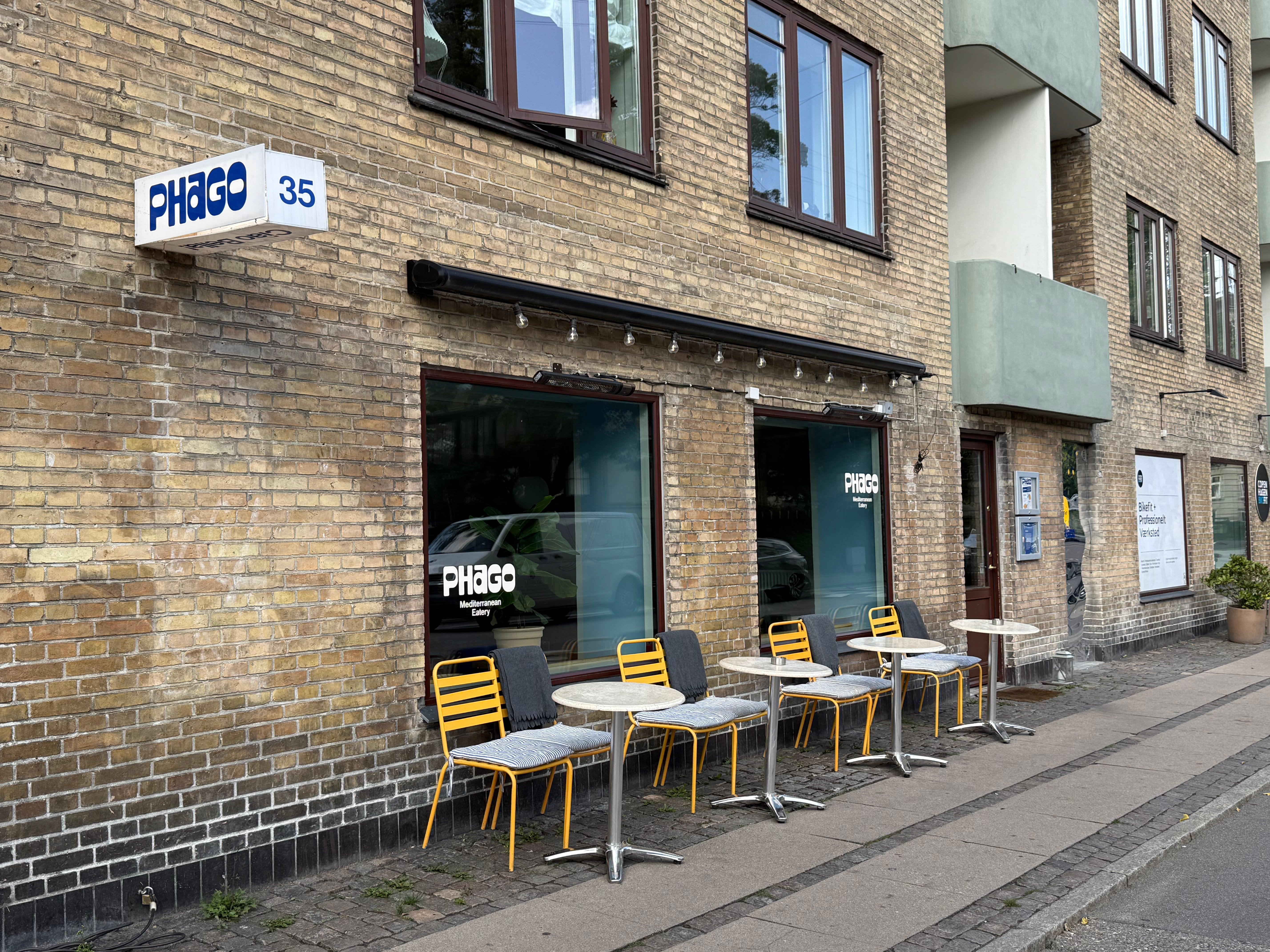 Randersgade 35, med et terrasseområde udenfor, hvor der er flere sæde og spisesteder, samt et skilt med teksten PHAGO 35