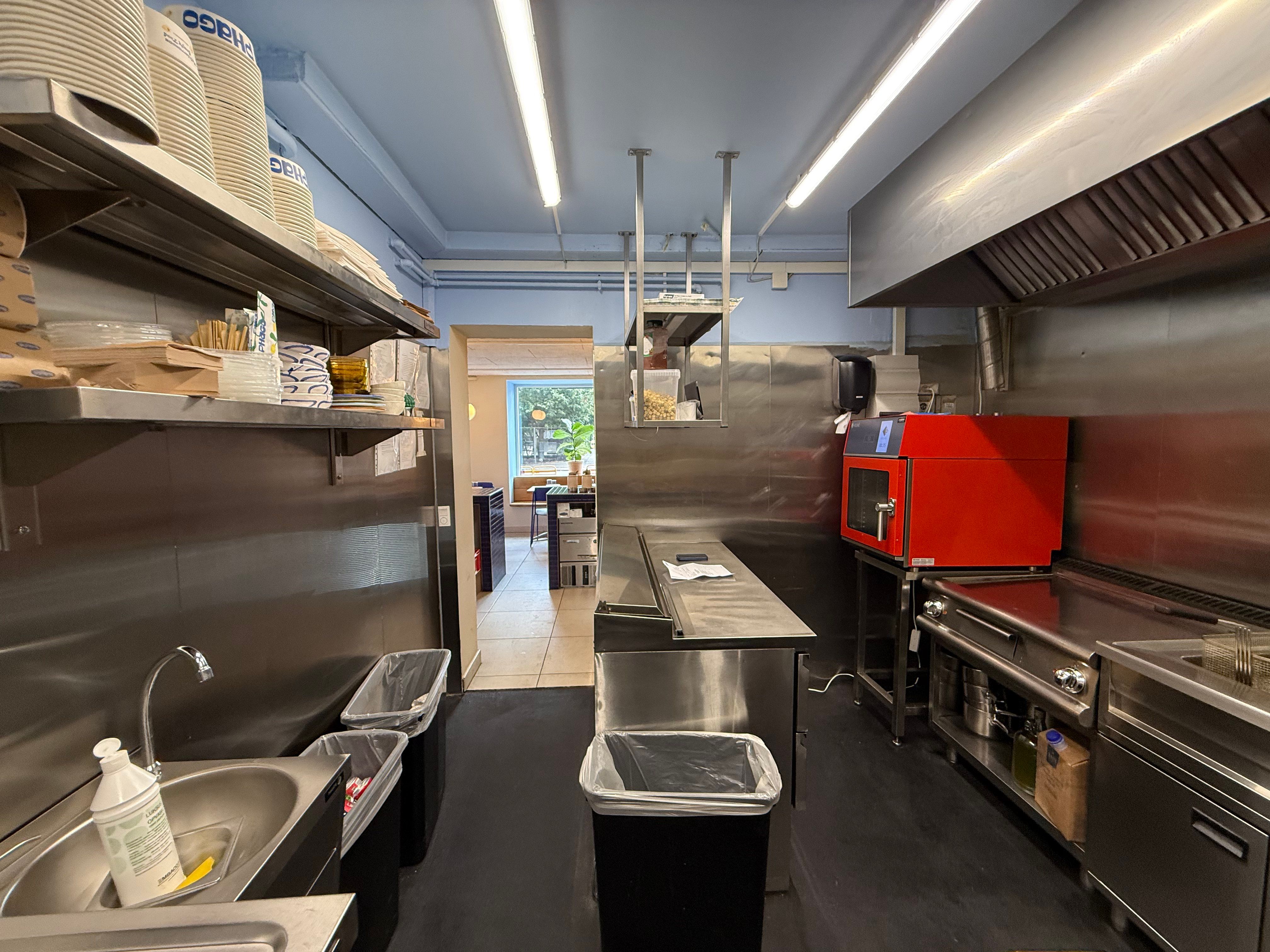 Rent og rens køkken med moderne udstyret, højloft, lyse og renser, ovn og flere beholdere på hylder