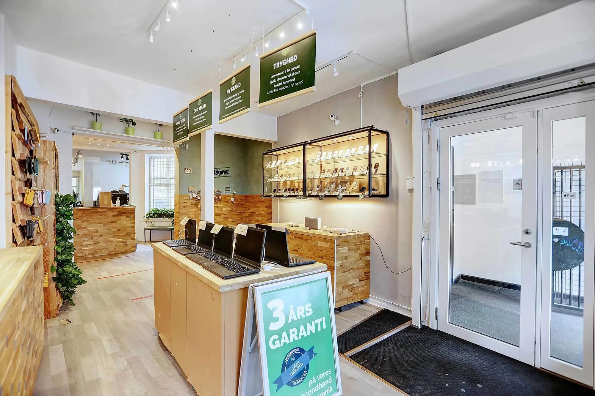 et moderne butikslokal med lyse loftslampe, eksklusive laptops på display og et 3 års garanti skilt i forgrunden
