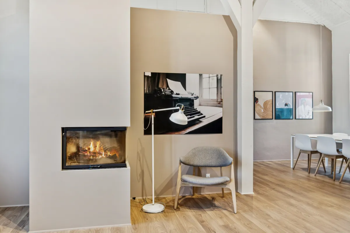 Kontorfællesskab med højloftede værelser, åben ildsted, højloftede værelser og moderne møbler og hvide vægge