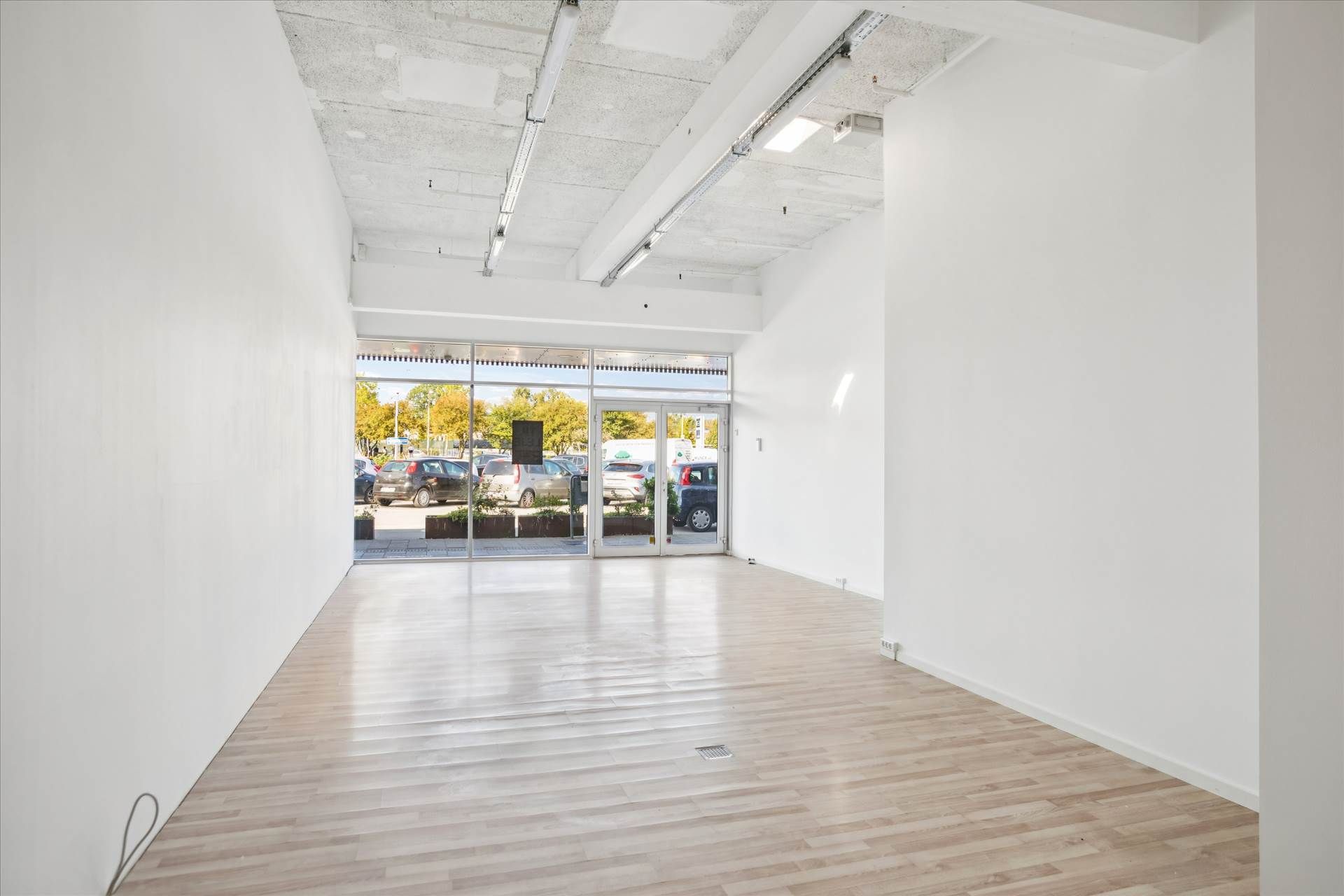 Lejemålet har en stor, lys og rummelig indgangsparti med trægulv og hvide vægge samt glasdøre