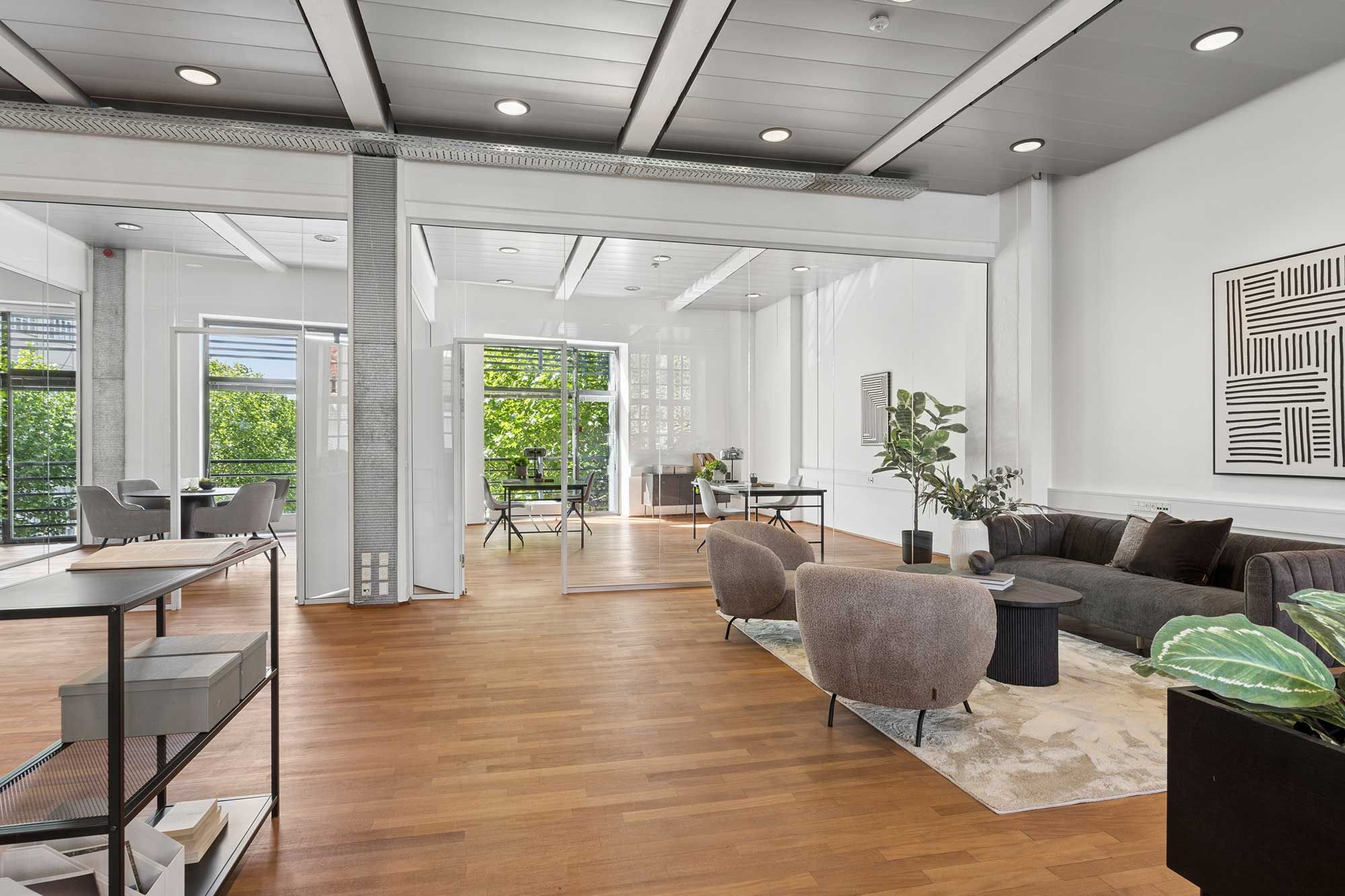 Kontorlokaler med højloft, trægulv, sofa, kaffebord, møbler, glasdøre, indretning, plantepot, indendørs terrasse, vinduer, møbler, stol, bord, skrivebord, plante