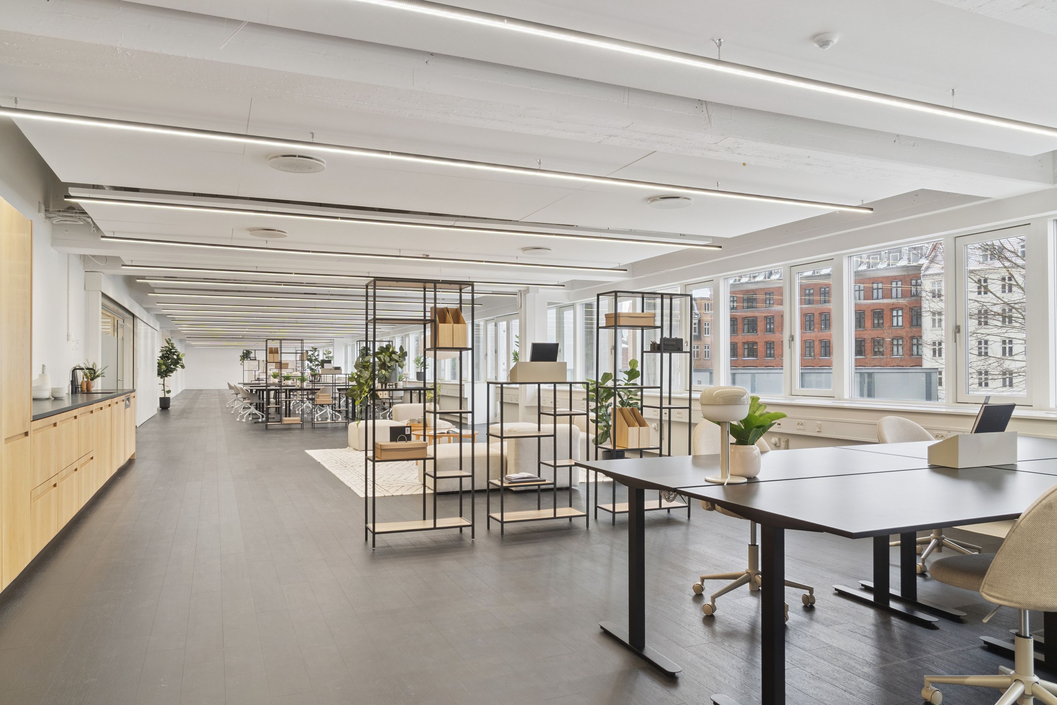 Kontor til leje med moderne møbler og lyse vinduer på Vesterbrogade. Elegante borde og stole, hvide vægge og en simpel indretning med lyse loftsbelægninger