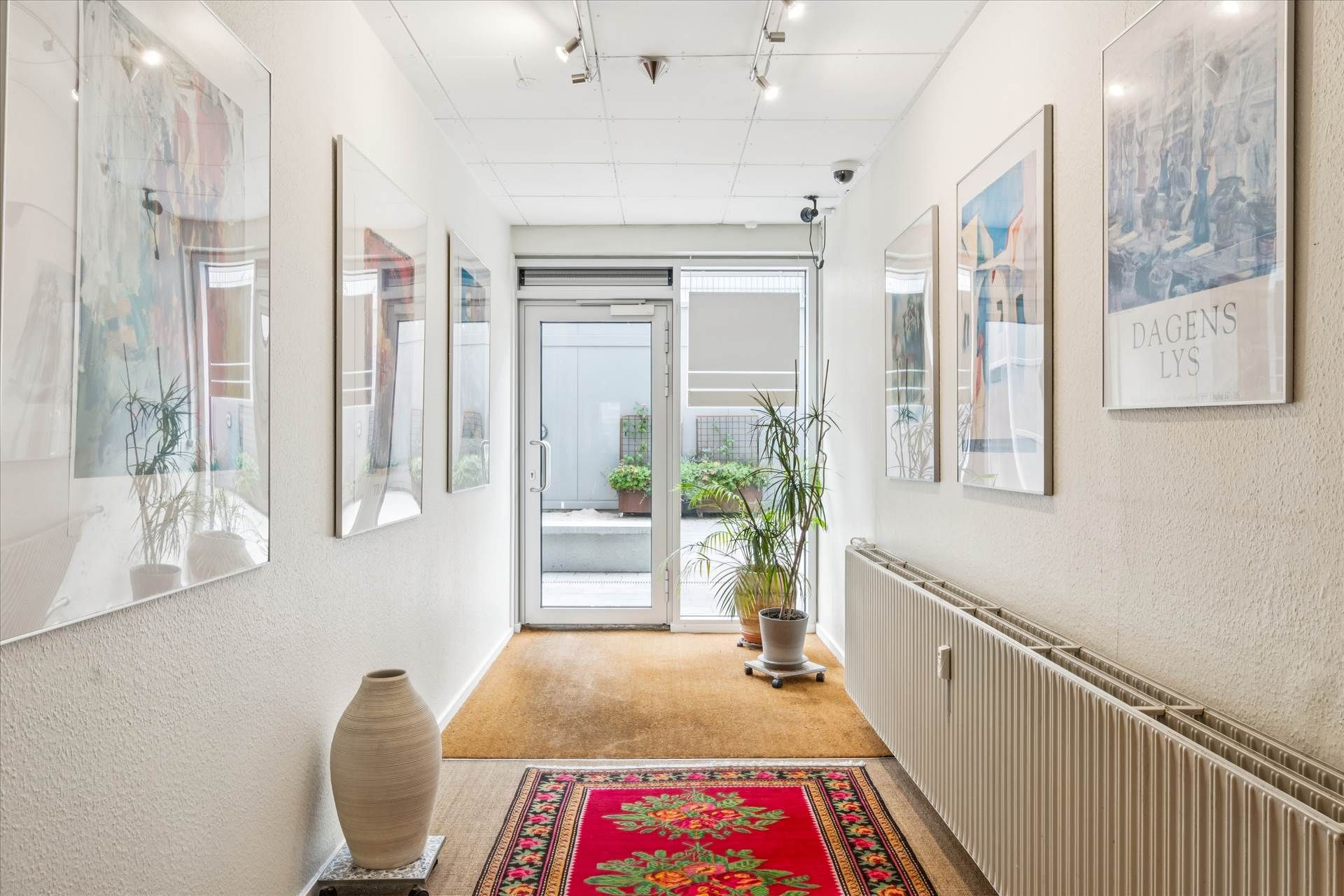 Et interiør med moderne møbler og kunstværker på væggen og en lysgrå gulvbelægning