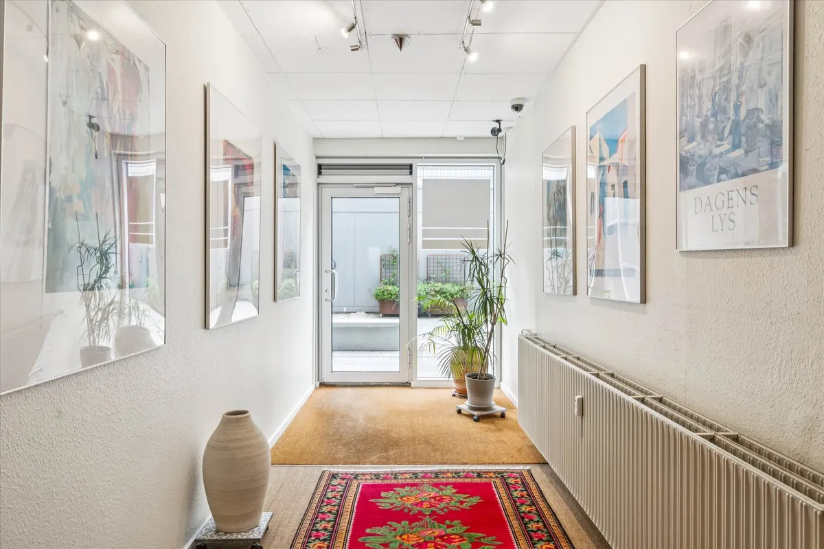 Et interiør med moderne møbler og kunstværker på væggen og en lysgrå gulvbelægning