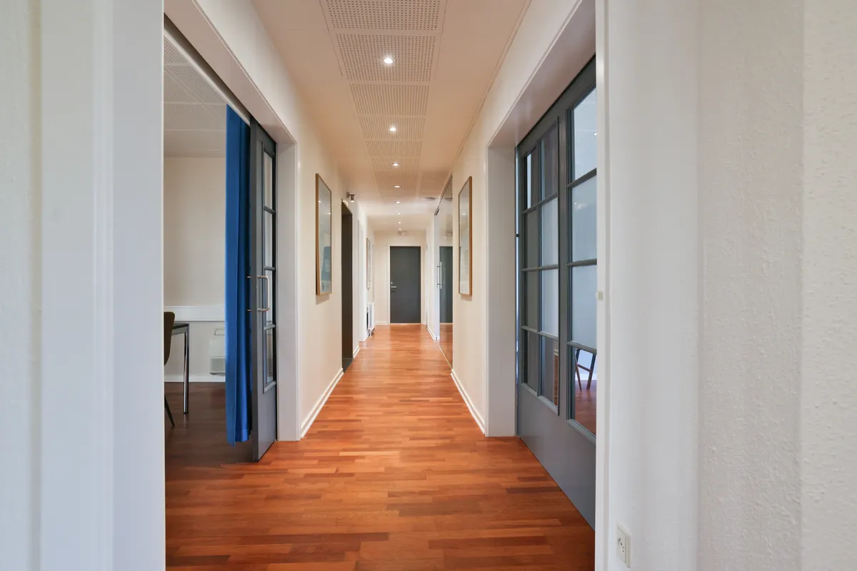 Kort og rummeligt kontor i Kontorfællesskabet Avisen i Ikast med lysegult gulv, hvide vægge og lyseblå døre