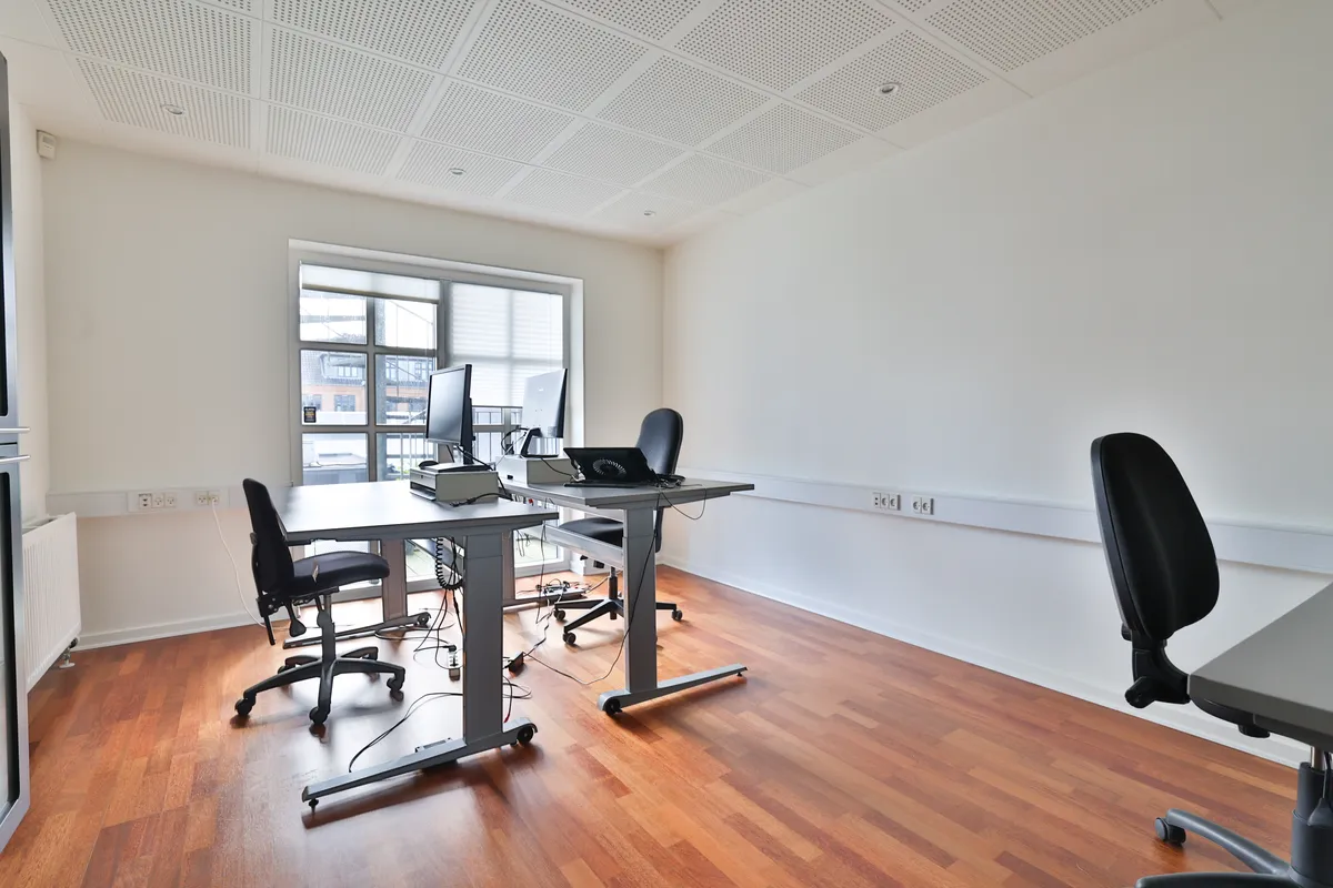 Kontor med højt til loftet og to bord med computere, der er til leje i Ikast