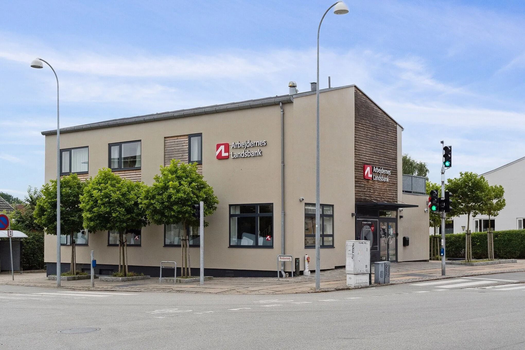 Landsbanken erhvervsejendom med solpaneler og udvendigt anbragte trafikskilte langs gågaden på Hvidovrevej
