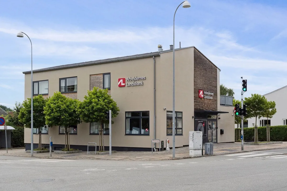 Landsbanken erhvervsejendom med solpaneler og udvendigt anbragte trafikskilte langs gågaden på Hvidovrevej