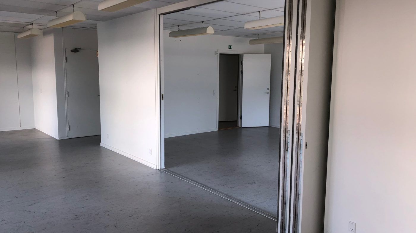 En tom kontor med lysegul væg og gulv og hvide døre og indvendige spejl