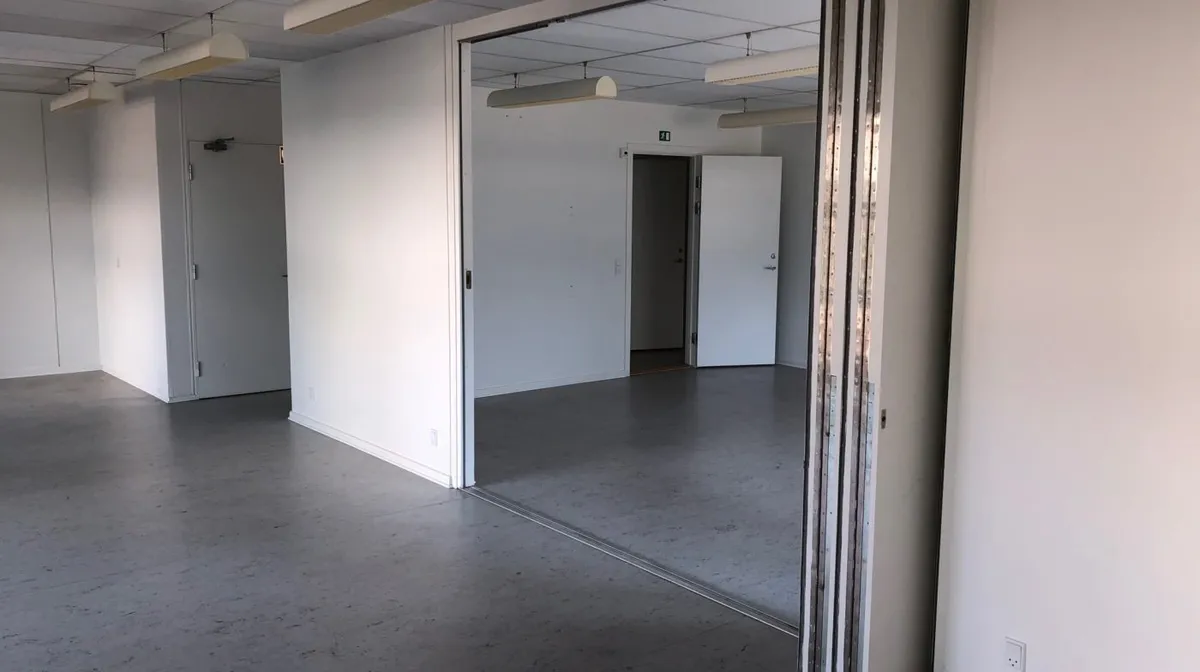 En tom kontor med lysegul væg og gulv og hvide døre og indvendige spejl